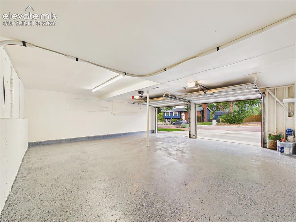 Image 39 of 50: Spacious oversized two-car garage with durable epoxy-coated flooring, brigh