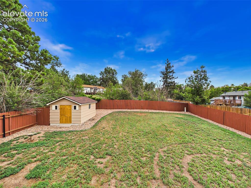 Image 44 of 50: Another view showcases the generous yard size, low-maintenance rock borders