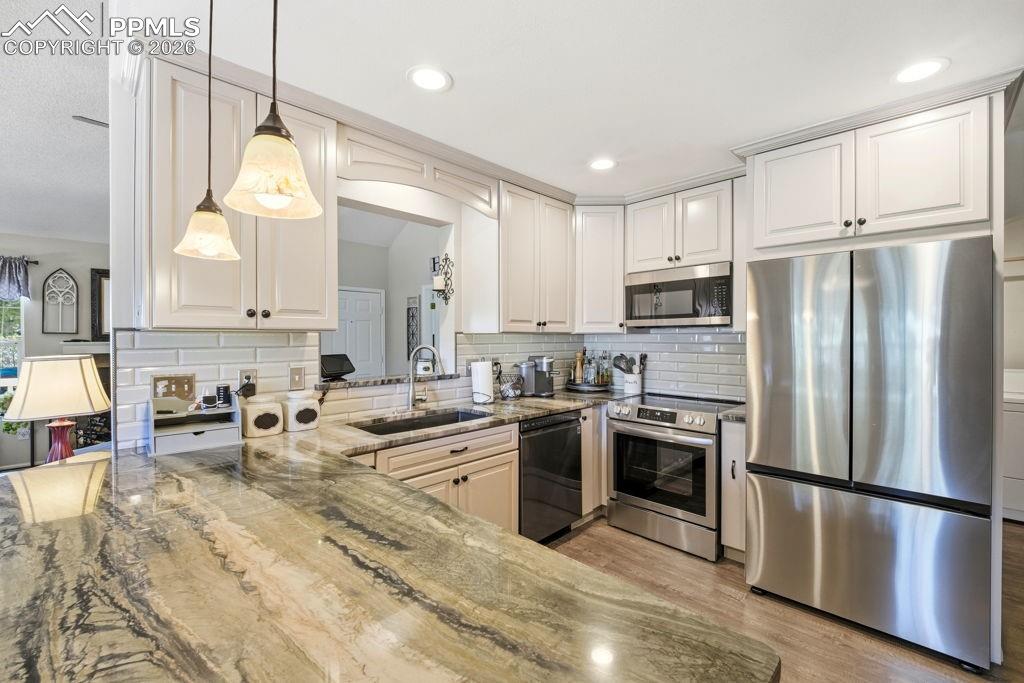 Image 17 of 41: Contemporary kitchen featuring light cabinetry, stainless steel appliances,