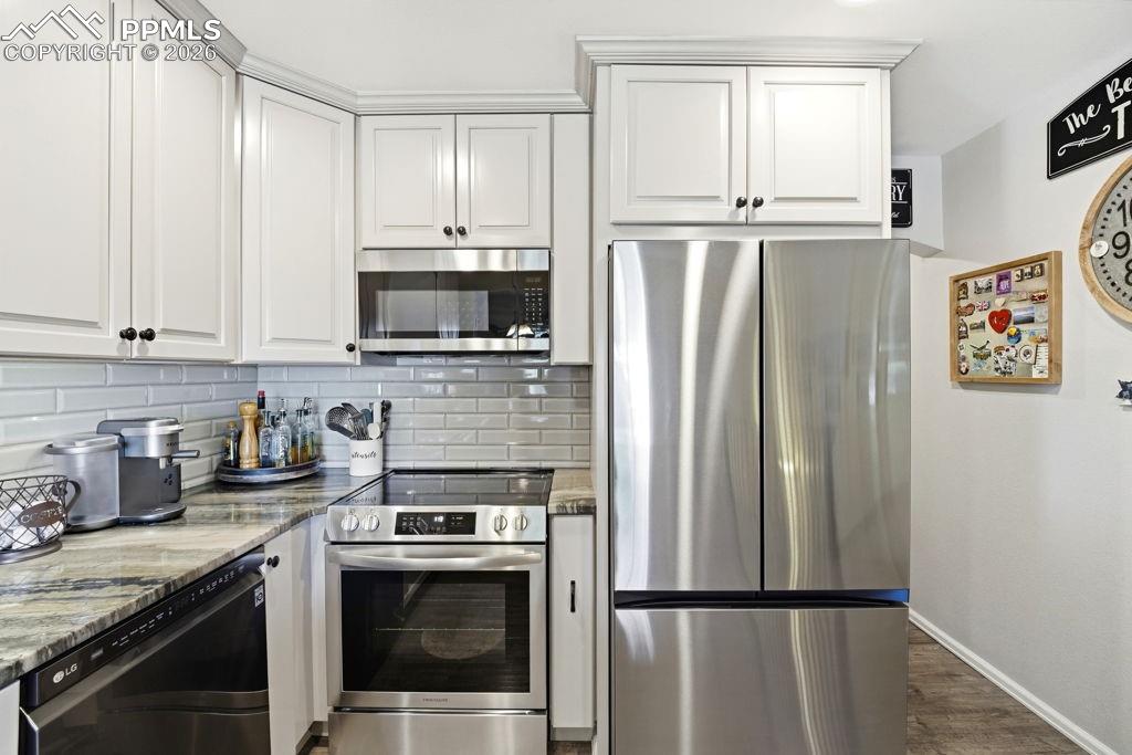 Image 18 of 41: Kitchen featuring white shaker-style cabinetry with crown molding, stainles