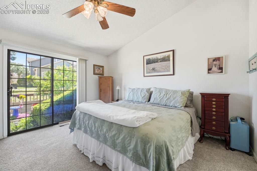 Image 22 of 41: Spacious owners suite featuring vaulted ceilings, neutral carpeting and wal