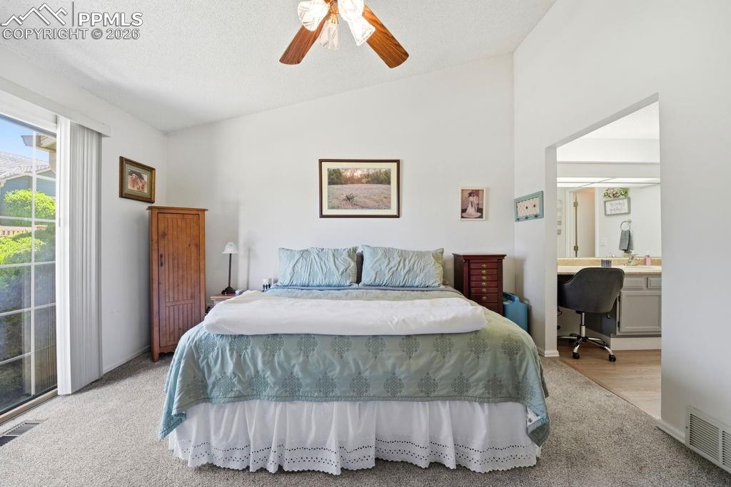 Image 23 of 41: Vaulted ceiling bedroom featuring carpeting, a sliding glass door, and acce