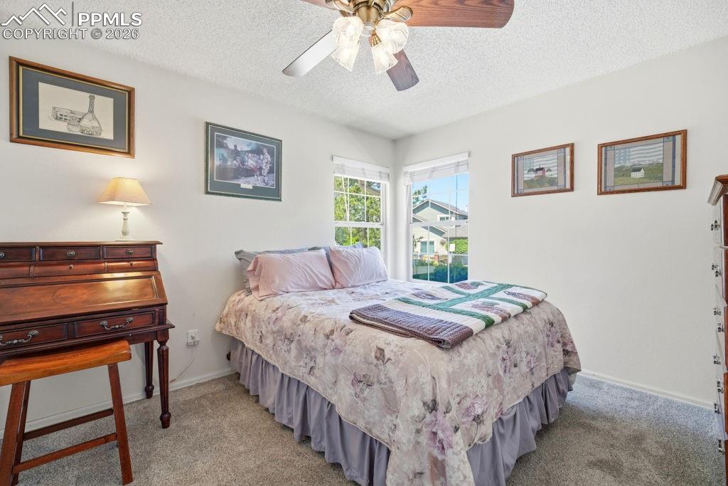 Image 26 of 41: Carpeted room featuring dual windows, a ceiling fan with integrated lightin