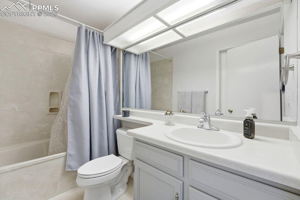 Image 29 of 41: Bathroom off main floor additional bedroom featuring an integrated vanity s