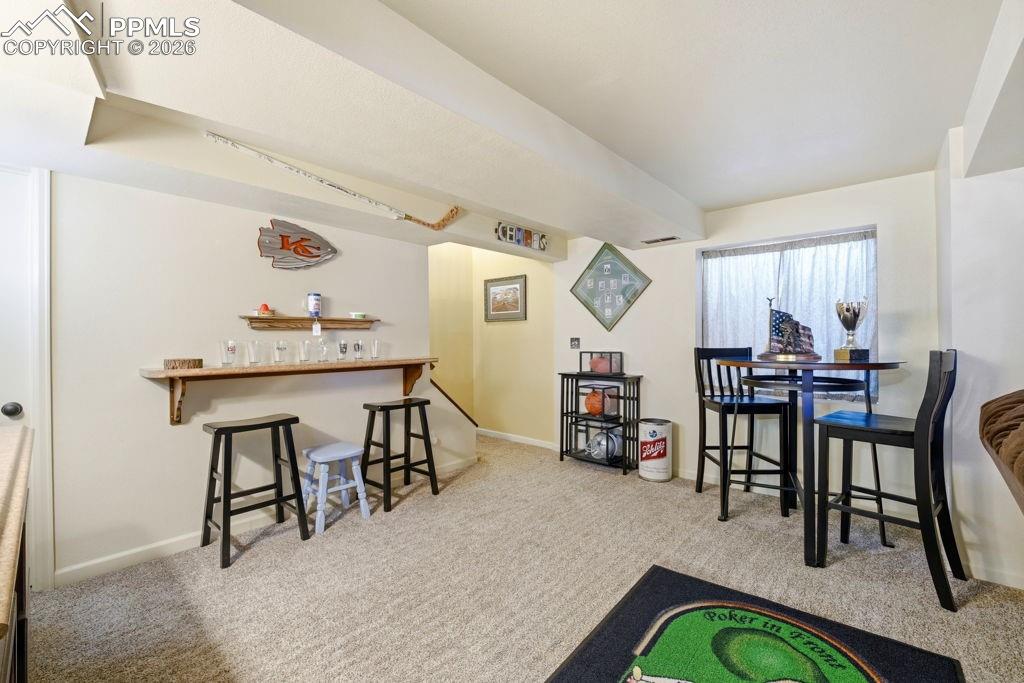 Image 30 of 41: Lower level space featuring a built-in wood shelf with bracket supports, a 