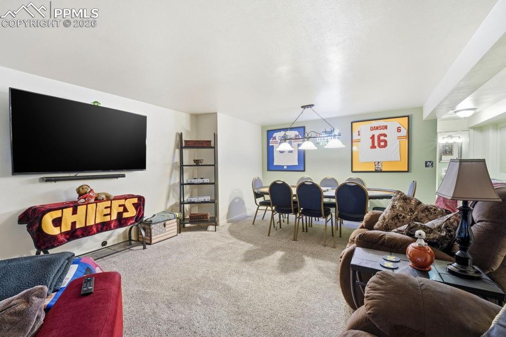 Image 34 of 41: Spacious carpeted room featuring a wall-mounted television, a built-in shel