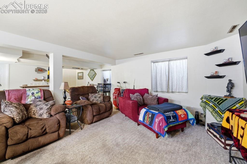 Image 36 of 41: Carpeted recreation room featuring white walls and a window with light-filt