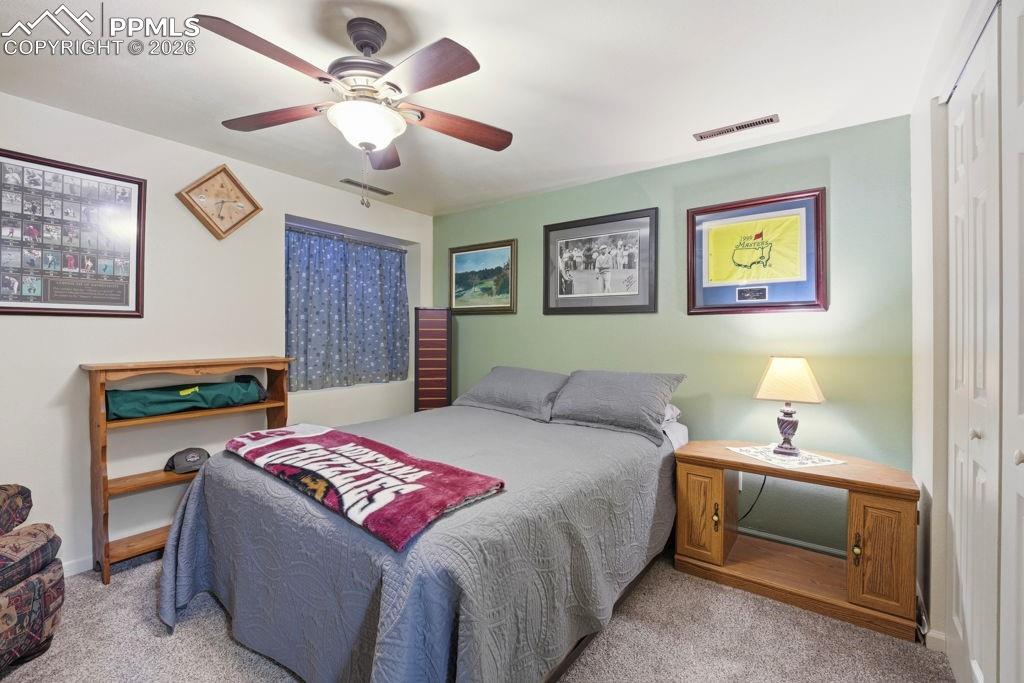 Image 37 of 41: Lower level carpeted bedroom featuring a ceiling fan with integrated lighti