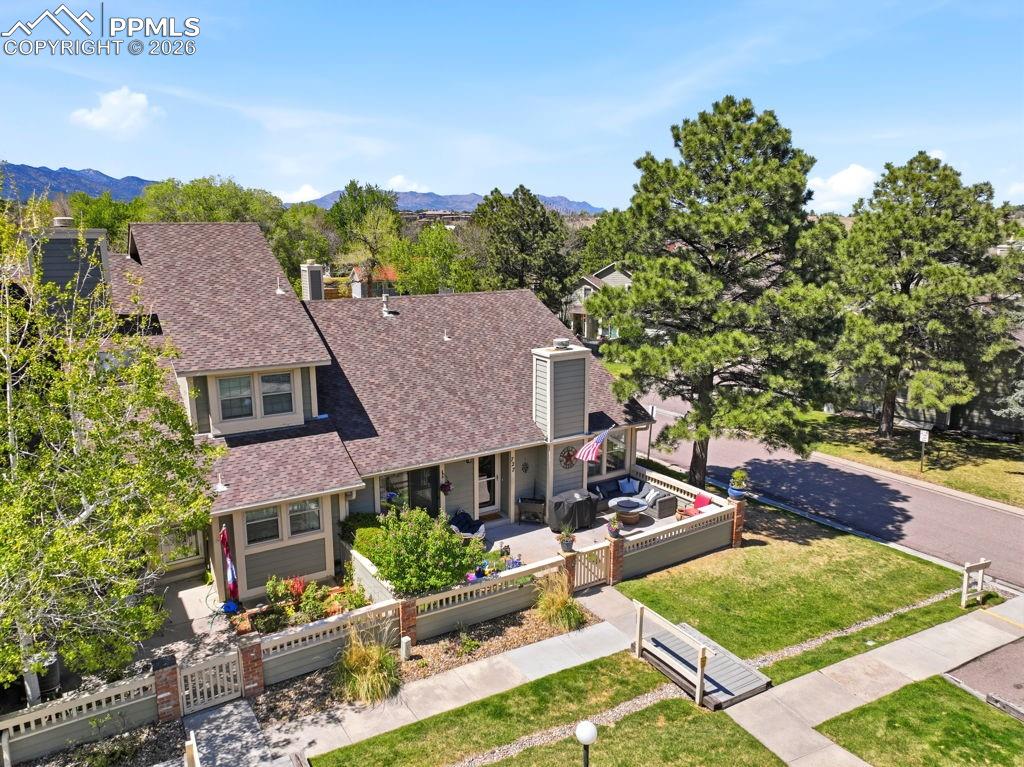 Image 7 of 41: Single-level property with shingled roofing and mountain backdrop (end unit
