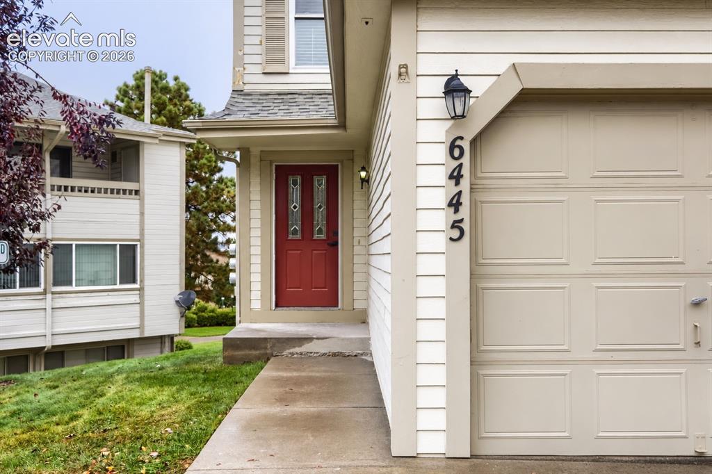 Image 1 of 25: Exterior entrance featuring light-colored horizontal siding, a bold red fro