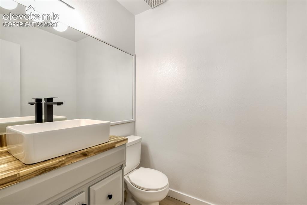 Image 11 of 25: Bathroom featuring a vanity with a light wood-tone countertop, rectangular 