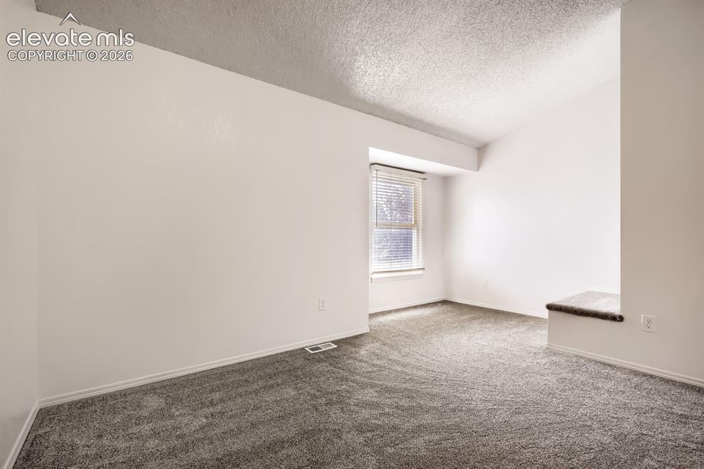 Image 13 of 25: Room featuring a vaulted ceiling, neutral wall finish, carpeted flooring, w