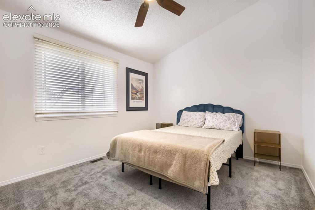 Image 15 of 25: Neutral interior with high ceilings, plush carpeting, and a ceiling fan wit