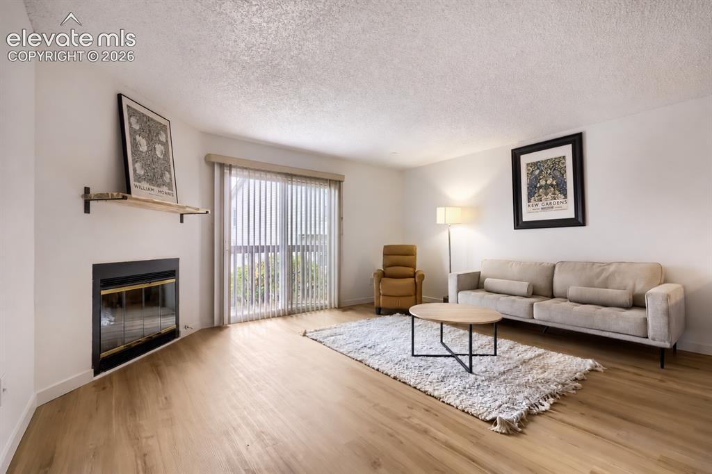 Image 3 of 25: Living space featuring wood-finish flooring, a built-in fireplace with a bl