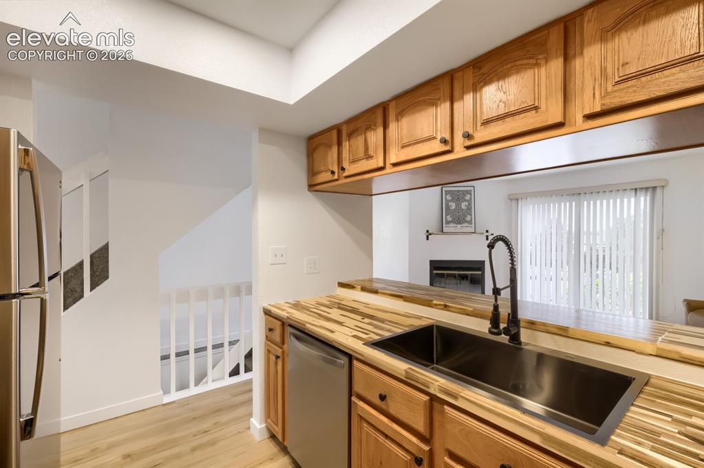 Image 9 of 25: Kitchen featuring butcher block countertops, undermount rectangular sink wi