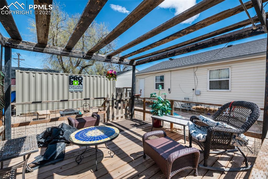 Image 25 of 26: Wooden deck with a pergola and an outdoor living space