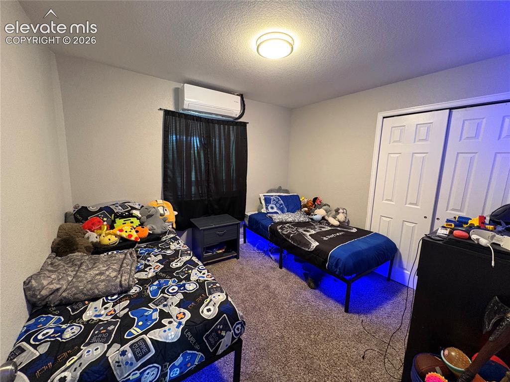 Image 5 of 11: Carpeted room featuring a ceiling-mounted light fixture, split-unit air con