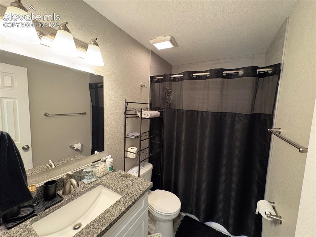 Image 7 of 11: Bathroom featuring a granite-finish vanity with an undermount sink, brushed