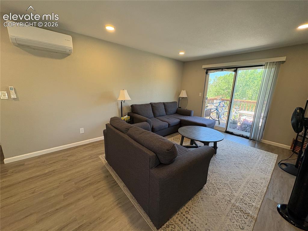 Image 8 of 11: Living area featuring wood-finish flooring, recessed lighting, and a ductle