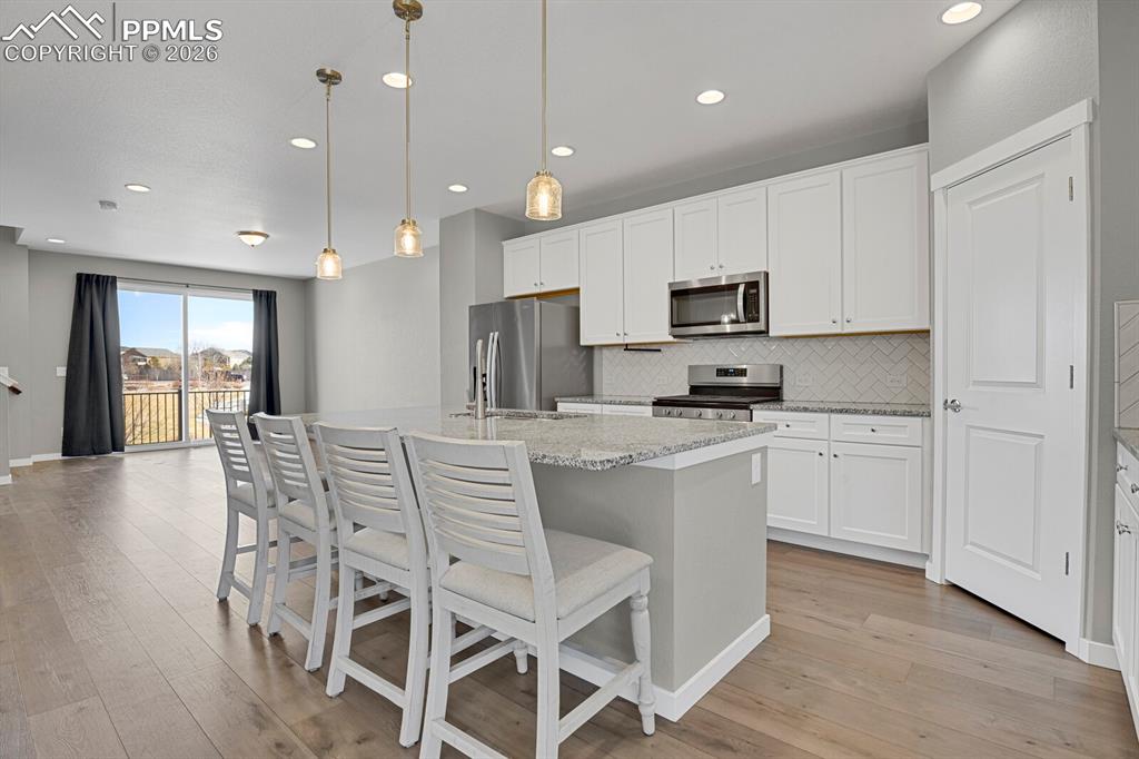 Image 12 of 40: Kitchen with white cabinets and Pantry