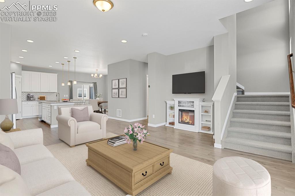 Image 4 of 40: Virtually staged photo , Living room featuring a stand alone Electric glass