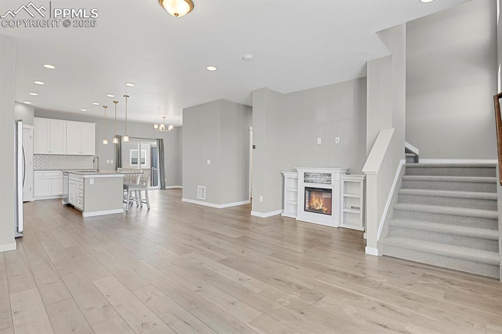 Image 5 of 40: Unfurnished living room with a stand alone Electric glass covered fireplace