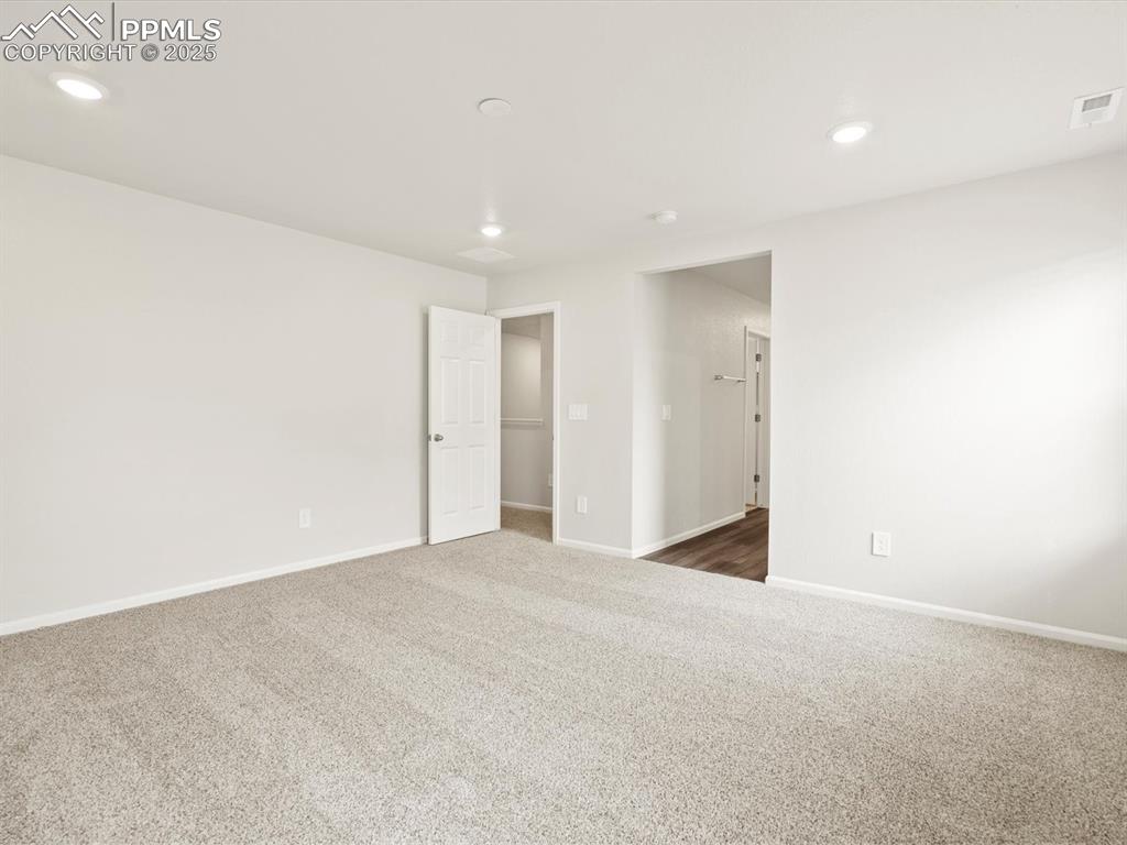 Image 12 of 23: Unfurnished room featuring dark carpet and recessed lighting