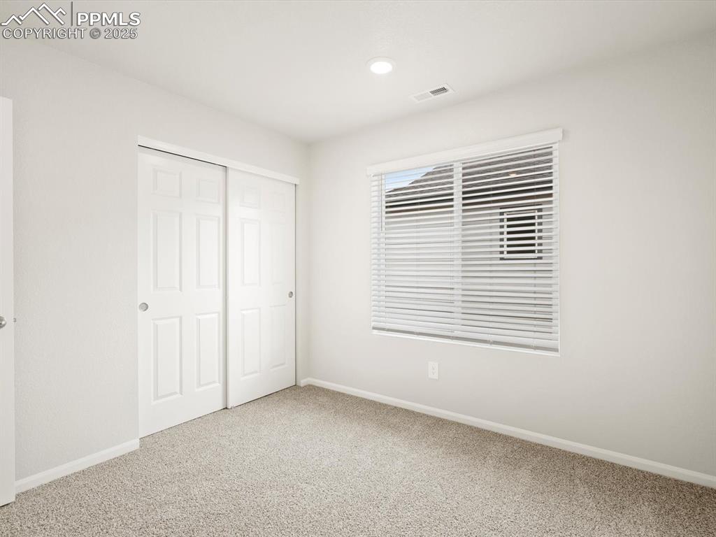 Image 16 of 23: Unfurnished bedroom with carpet floors, a closet, and recessed lighting