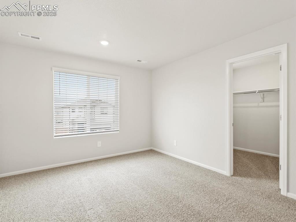 Image 17 of 23: Unfurnished bedroom featuring carpet flooring, a spacious closet, and reces