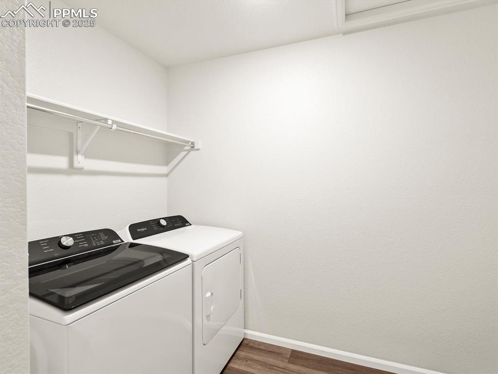 Image 20 of 23: Laundry room featuring washer and dryer and dark wood-type flooring