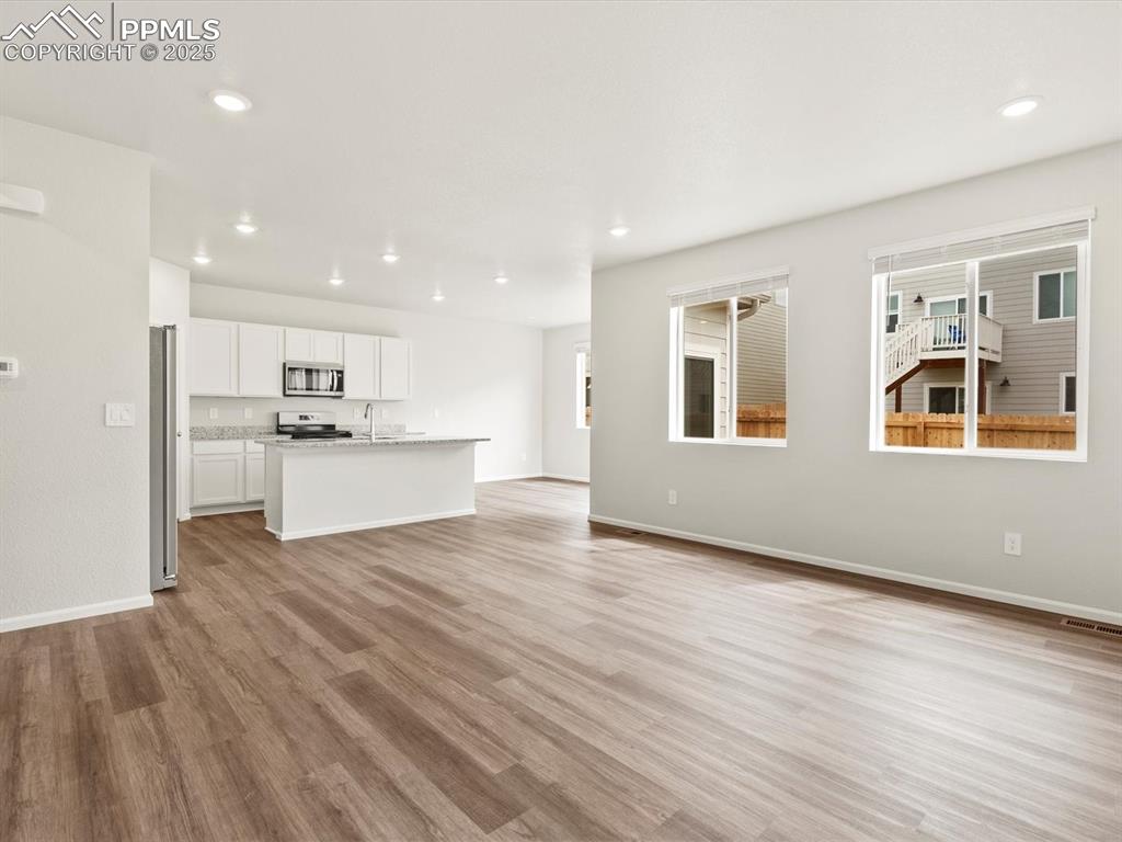 Image 5 of 23: Unfurnished living room featuring light wood finished floors and recessed l