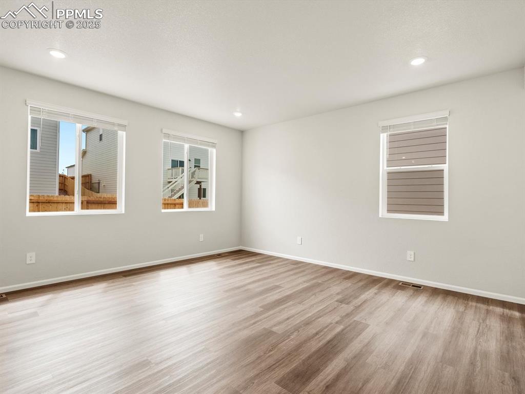 Image 7 of 23: Empty room featuring wood finished floors and recessed lighting