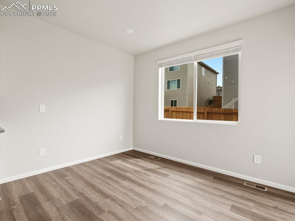 Image 9 of 23: Unfurnished room featuring wood finished floors and baseboards