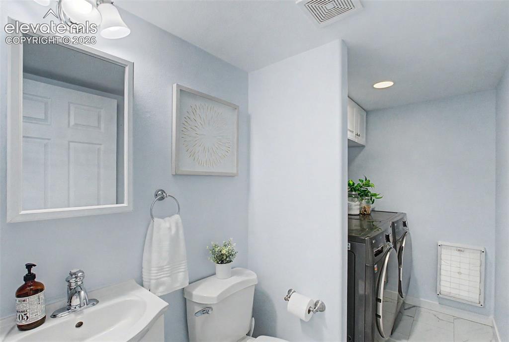 Image 18 of 50: A half bathroom and laundry room on main level