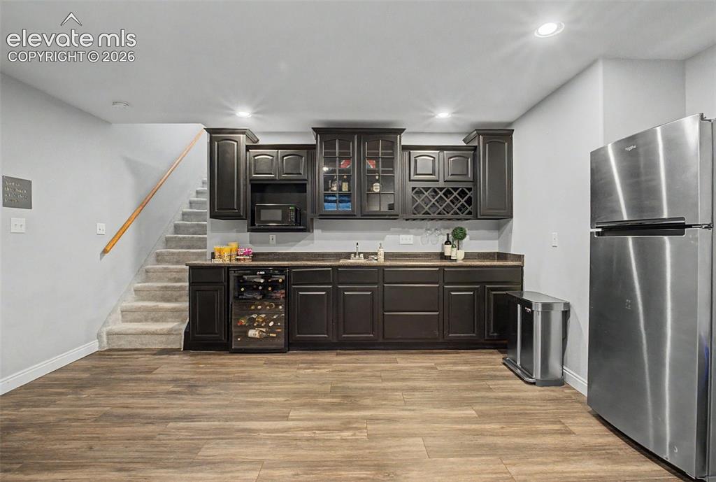Image 32 of 50: A wetbar and fridge are perfect for entertaining