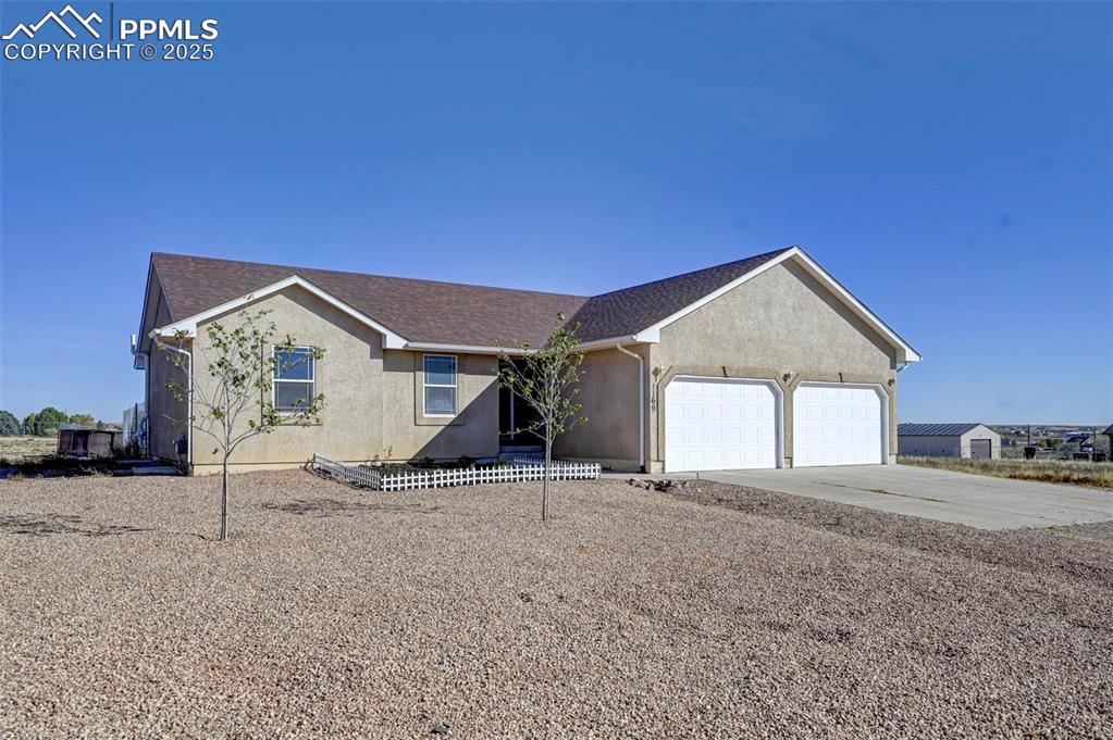 Caption: View of front facade featuring a shingled roof, concrete driveway, an attached garage, and stucco si