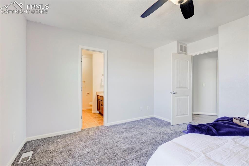 Image 16 of 37: Bedroom with visible vents, a ceiling fan, ensuite bath, baseboards, and li