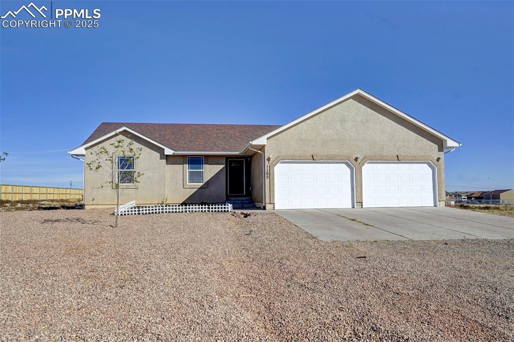 Image 2 of 37: View of front of property featuring stucco siding, driveway, fence, roof wi