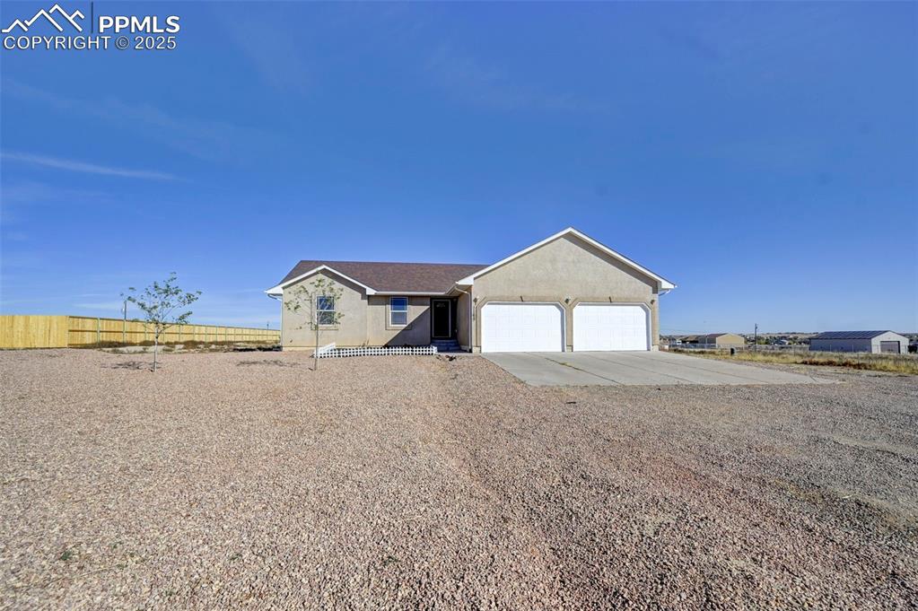 Image 3 of 37: View of front of property with stucco siding, an attached garage, concrete 