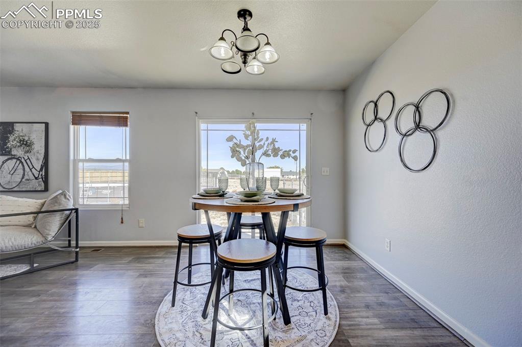 Image 9 of 37: Dining area featuring an inviting chandelier, dark wood-style floors, and b