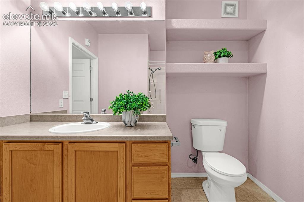 Image 11 of 27: Vanity with integrated sink, wood-finish cabinetry, and a full-width mirror
