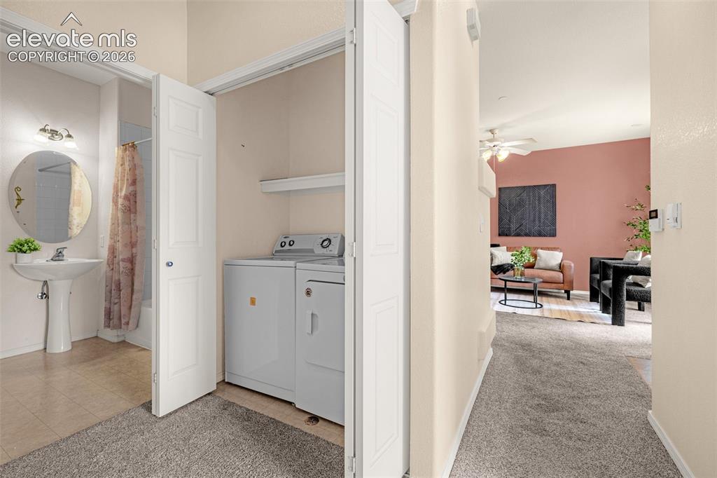 Image 14 of 27: Pedestal sink, round vanity mirror, built-in shelving, carpeted flooring, a
