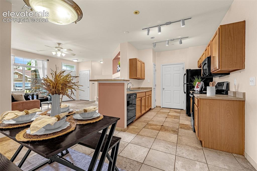 Image 17 of 27: Kitchen featuring wood-finish cabinetry, black appliances, track lighting, 