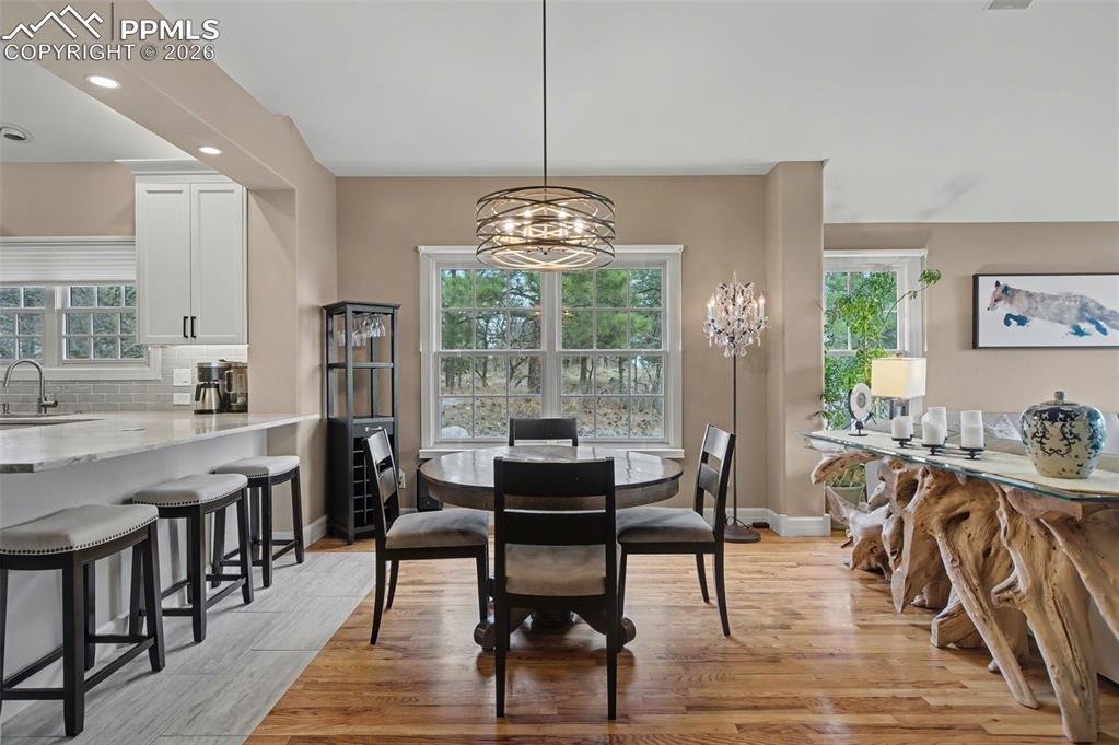 Image 13 of 45: Natural wood floors anchor the dining area, seamlessly tying together the m