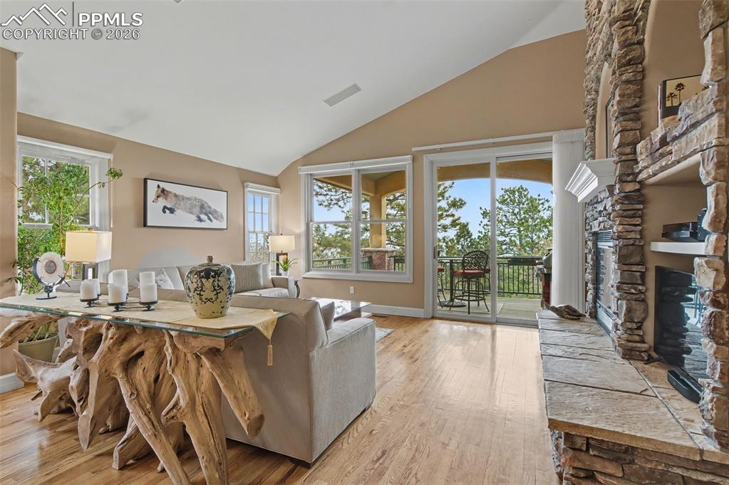 Image 14 of 45: Anchored by a striking gas fireplace and vaulted ceilings, the great room s