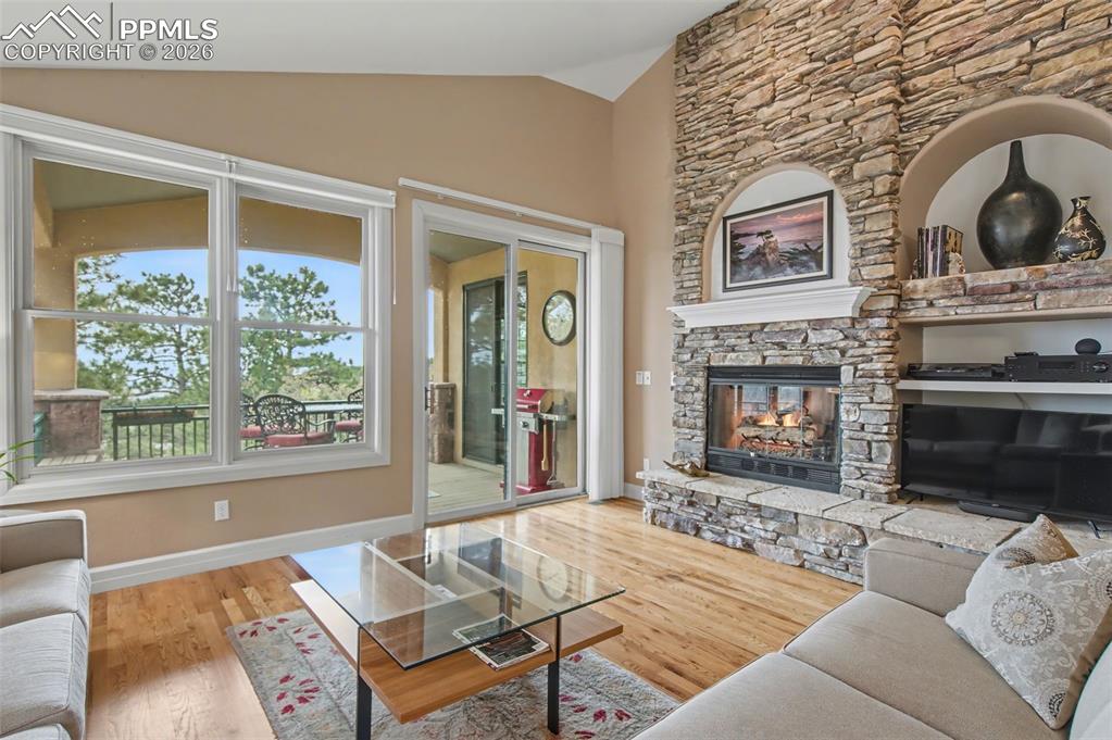 Image 18 of 45: Custom built-ins and a media alcove frame the commanding stone fireplace, c