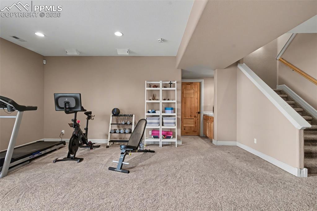 Image 32 of 45: A versatile lower-level space effortlessly serves as a private home gym, en