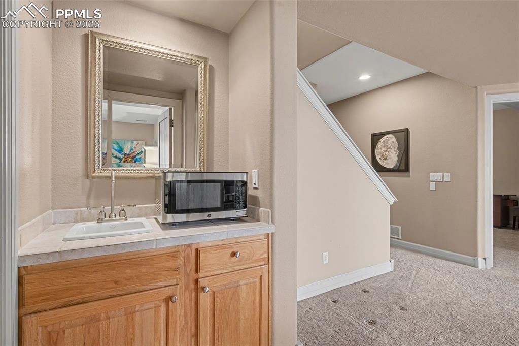 Image 33 of 45: The lower level features a convenient built-in wet bar, making this floor c