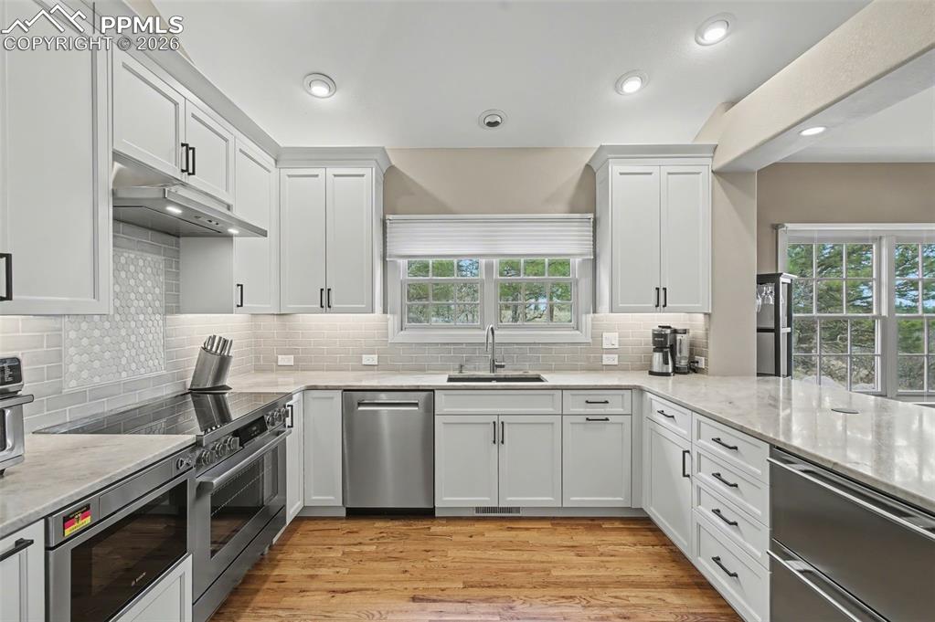 Image 6 of 45: The newly updated gourmet kitchen boasts pristine stone countertops, a mode
