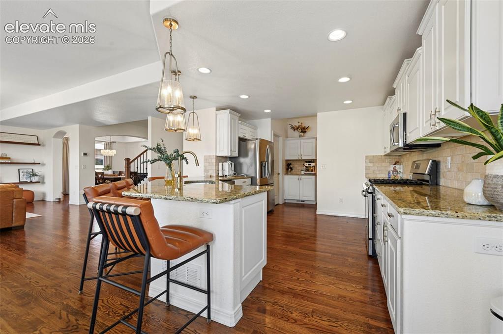 Image 10 of 50: Kitchen featuring granite countertops, stainless steel appliances, white ca